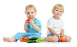 © Andrey Kuzmin - Two happy kids eating healthy food fruits and vegetables