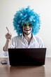 © Eugenio Marongiu - funny crazy young man with blue wig using notebook