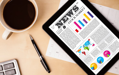 Wall Mural - tablet pc shows news on screen with a cup of coffee on a desk