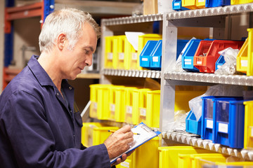 Wall Mural - Worker Checking Stock Levels In Store Room