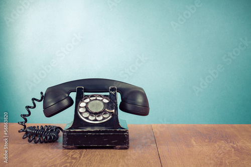 Fotografia Retro telephone on table in front mint green background