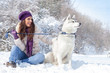 © luckybusiness - Young woman with her dog in snow