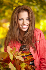 Sticker - Beautiful elegant woman standing in a park in autumn