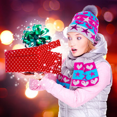 Woman looks into the christmas box  with magic lights