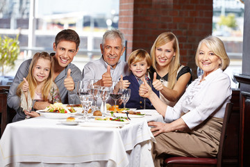 Wall Mural - Familie im Restaurant hält die Daumen hoch