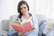 © lightwavemedia - Pretty casual brown haired woman in white pajamas reading a book