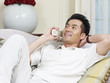 © imtmphoto - asian man talking on phone at home