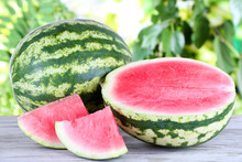 Ripe Watermelons On Wooden Table On Nature Background