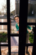 Housewife looking through glass door