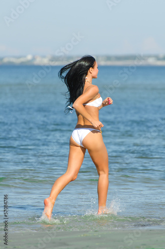 Board z aluminiowym obramowaniem Zmysłowa brunetka biegająca po plaży. 