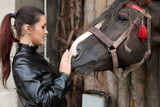 Fototapeta  - Piękna dziewczyna pieści łeb konia.