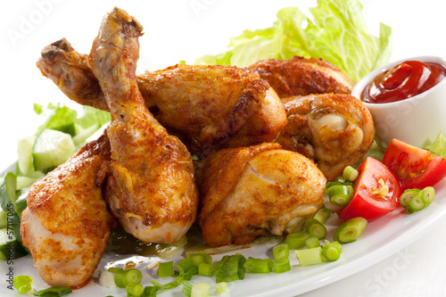 Fototapeta do kuchni Grilled chicken legs and vegetables on white background