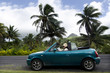 Young woman traveling by convertible car in a Pacific Island