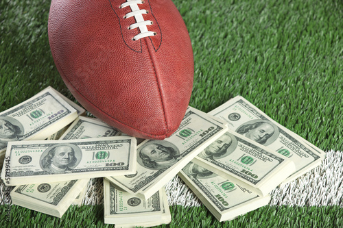 Board z aluminiowym obramowaniem Nfl piłki nożnej na polu ze stosem pieniędzy