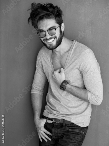 Fototapeta na wymiar sexy man with beard dressed casual smiling against wall