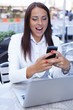 © Nejron Photo - Surprised young brunette woman alone with laptop and mobile phon