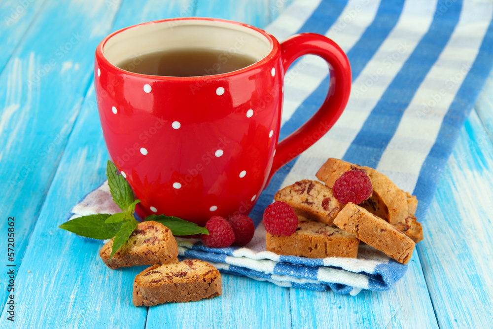 Cup of tea with cookies and raspberries on table close-up