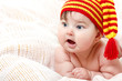 © Khorzhevska - cute baby lying on pink plaid in vivid funny hat, beautiful kid'