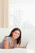 © WavebreakMediaMicro - Beautiful woman lying on sofa with notebook in front of her smil