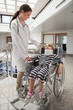 © WavebreakmediaMicro - Female doctor smiling at child in wheelchair and neck brace