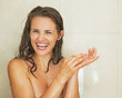 © Alliance - Portrait of smiling young woman taking shower