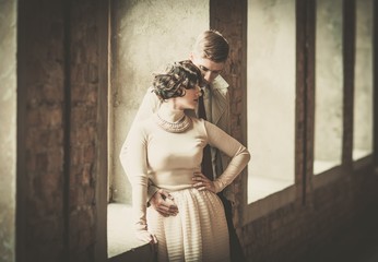 Beautiful vintage style couple standing near window