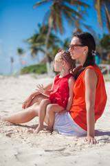 Poster - Little girl with her young mom relaxing on carribean beach