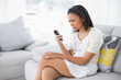 © lightwavemedia - Puzzled young dark haired woman in white clothes using a mobile