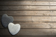 Stone Hearts On Wooden Boardwalk With Sand