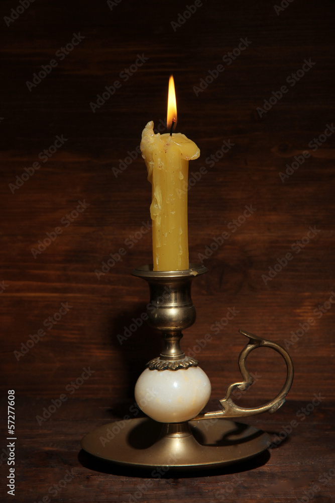 Old candle on table on wooden background