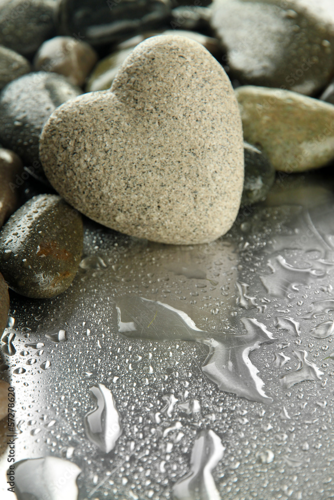 Grey stone in shape of heart, on light background