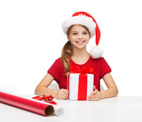 Canvas Print - smiling girl in santa helper hat with gift box