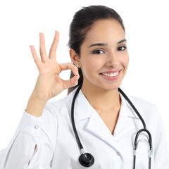 Wall Mural - Beautiful young doctor woman smiling and gesturing ok isolated