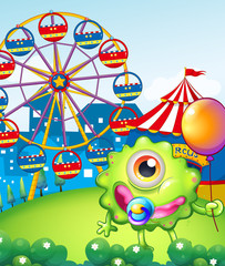 Poster - A young one-eyed monster holding a balloon near the carnival