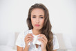 Tired beautiful brunette holding a tissue
