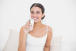 © lightwavemedia - Charming young brown haired model in white pajamas drinking wate