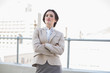 © lightwavemedia - Attractive stylish brown haired businesswoman standing with arms