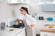 © lightwavemedia - Concentrated pretty woman with apron cooking