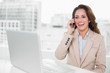 © lightwavemedia - Laughing businesswoman on the phone at her desk