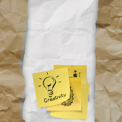 sticky note with  light bulb on crumpled paper as creative conce