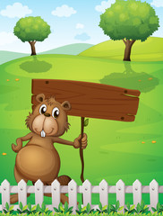 Poster - A beaver holding an empty signboard standing near the fence