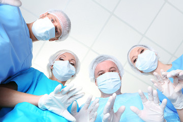 Canvas Print - View from below of surgeons in protective work wear during