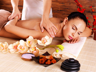 Masseur doing massage on woman body in spa salon