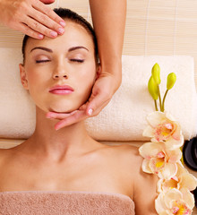 Wall Mural - Masseur doing massage the head of an woman in spa salon