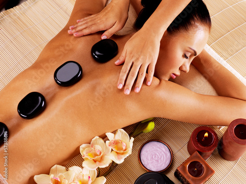 Naklejka dekoracyjna Adult woman having hot stone massage in spa salon