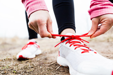 Wall Mural - Woman runner tying sport shoes