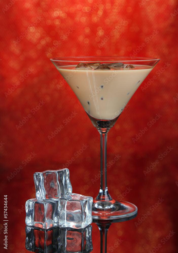 Baileys liqueur in glass on red background