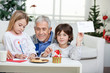 © Tyler Olson - Boy Showing Letter While Grandfather Assisting Girl