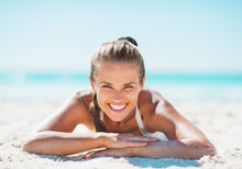 Portrait Of Smiling Woman In Swimsuit Laying On Sandy Beach