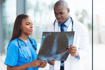 Wall Mural - african american medical workers studying patient's x-ray